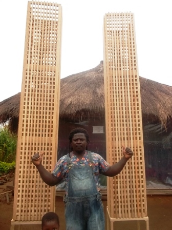 C-CELESTINE  INFRONT OF HIS ARTS WORK 4M TALL MADE OUT OF LOCAL BAMBOO.JPG