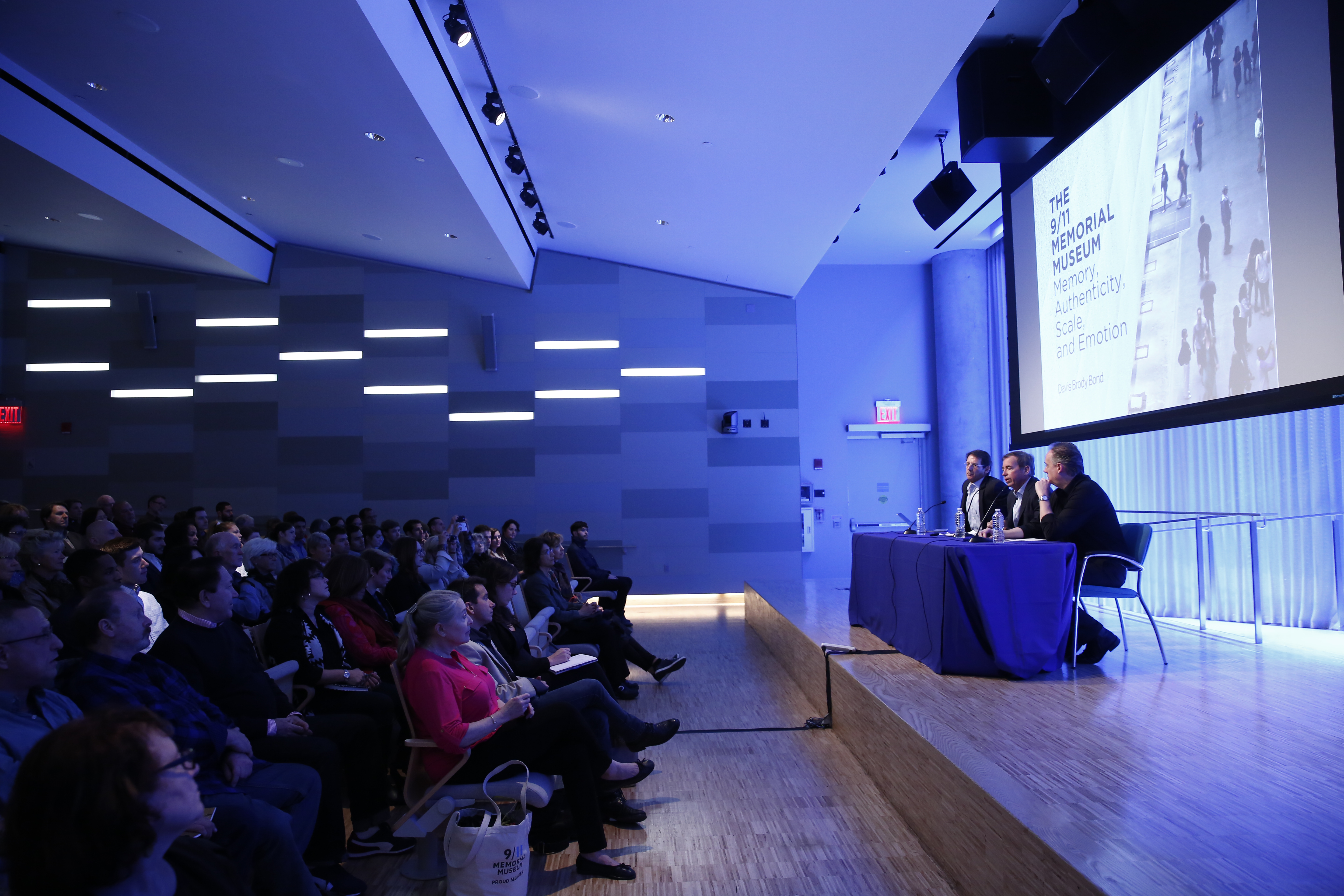 Several people sit at a table onstage as they take part in a public program at the Museum Auditorium.