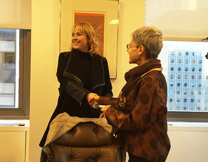 Survivor Adriana Maluendas gives her passport from 2001 to 9/11 Memorial Museum senior oral historian Amy Weinstein at the Brazilian consulate.