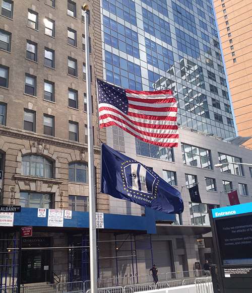 An American flag and a 9/11 Memorial & Museum flag stand at half mast outside the entrance to the Memorial on the 12th anniversary of the attacks.