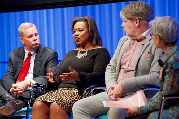 Lolita Jackson, a survivor of both the 1993 and 2001 attacks on the World Trade Center, gestures as she speaks onstage at the Museum auditorium. A man sits to her right and a man and woman sit to her left.