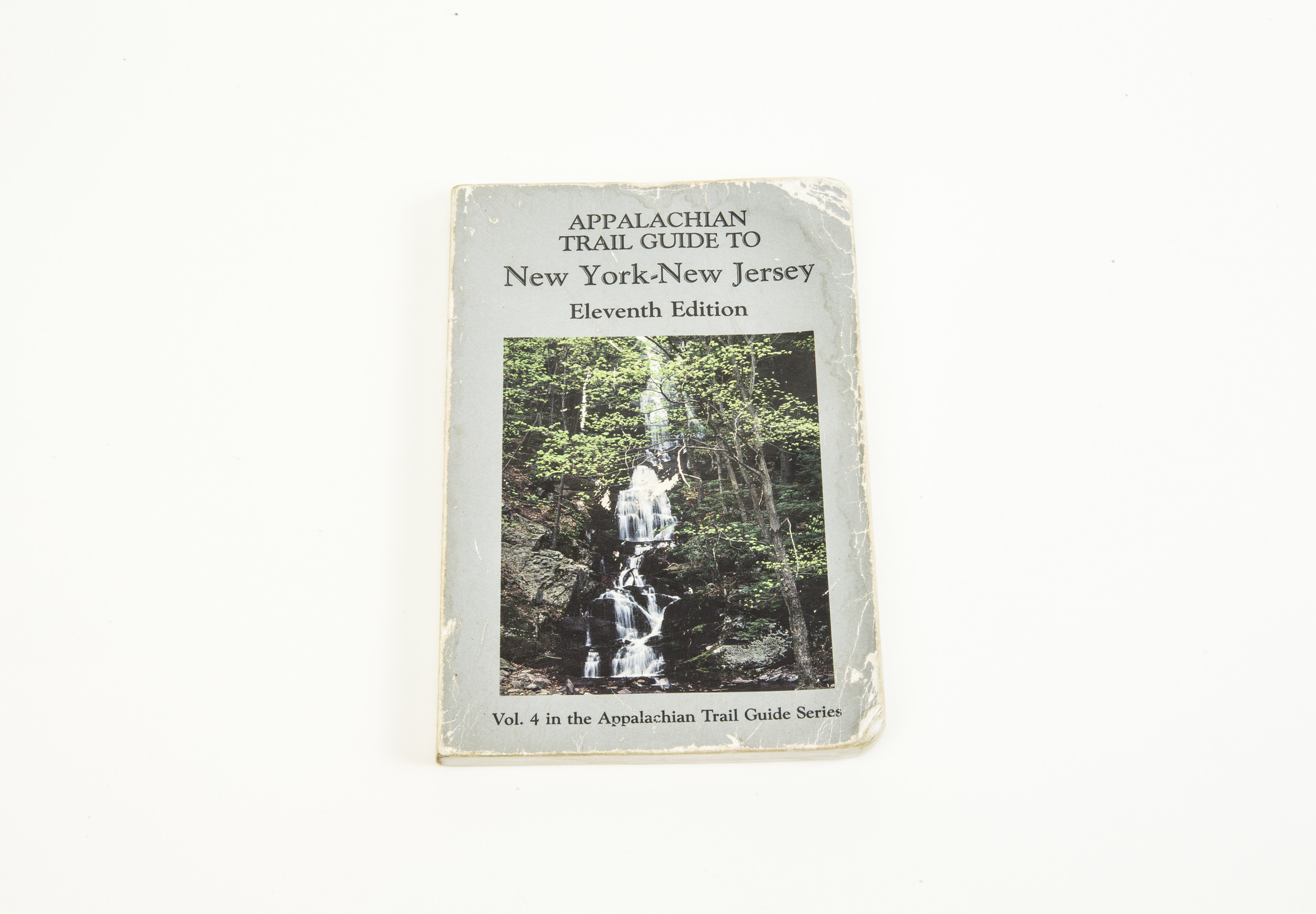 An Appalachian trail guidebook belonging to Bruce Van Hine is displayed on a white surface. The book includes a cover image of a waterfall.