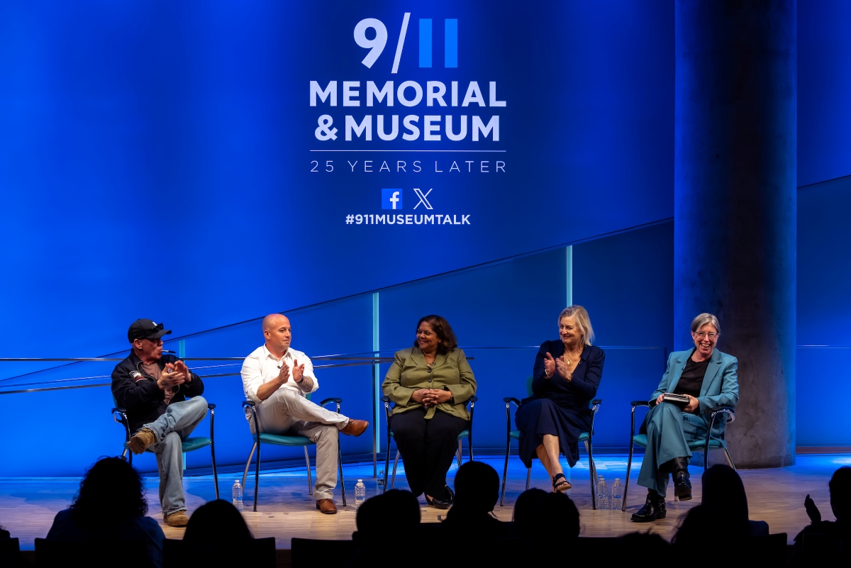 five people sit on stage with a blue background