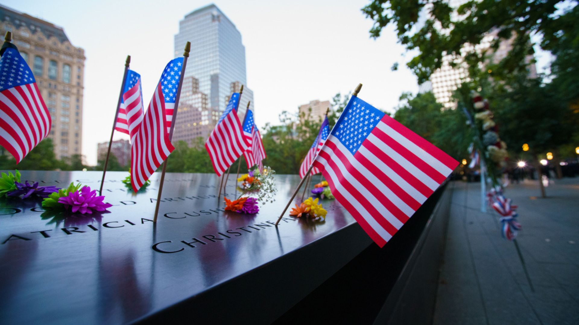 Small American flags placed in names along the Memorial parapet