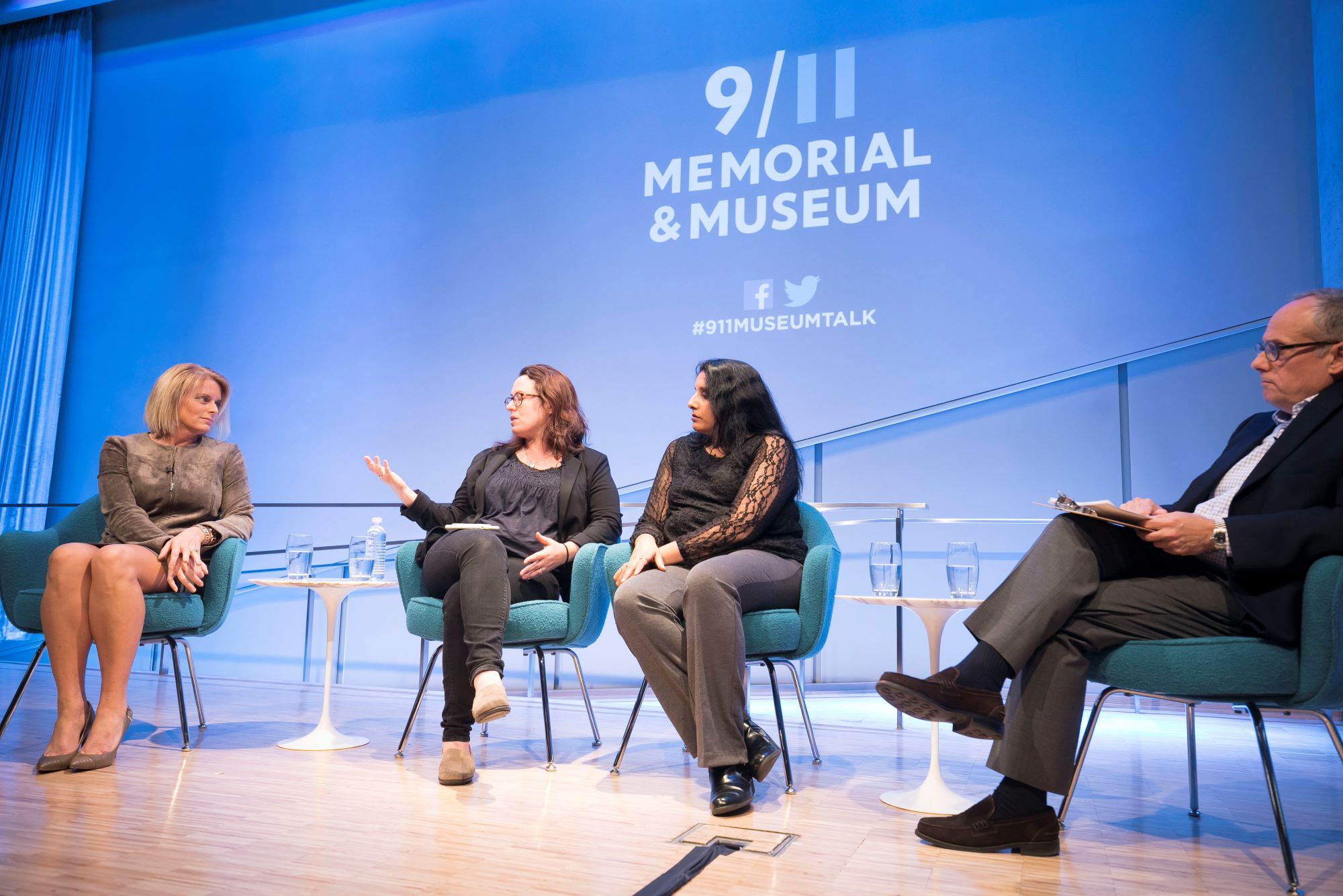 NY1 anchor Kristen Shaughnessy, New York Times correspondent and CNN analyst Maggie Haberman, and Associated Press reporter Deepti Hajela are seen seated onstage at the Museum Auditorium. Haberman is speaking and gesturing as the other participants listen on. Clifford Chanin, the executive vice president and deputy director for museum programs is to their right, listening and holding a clipboard.