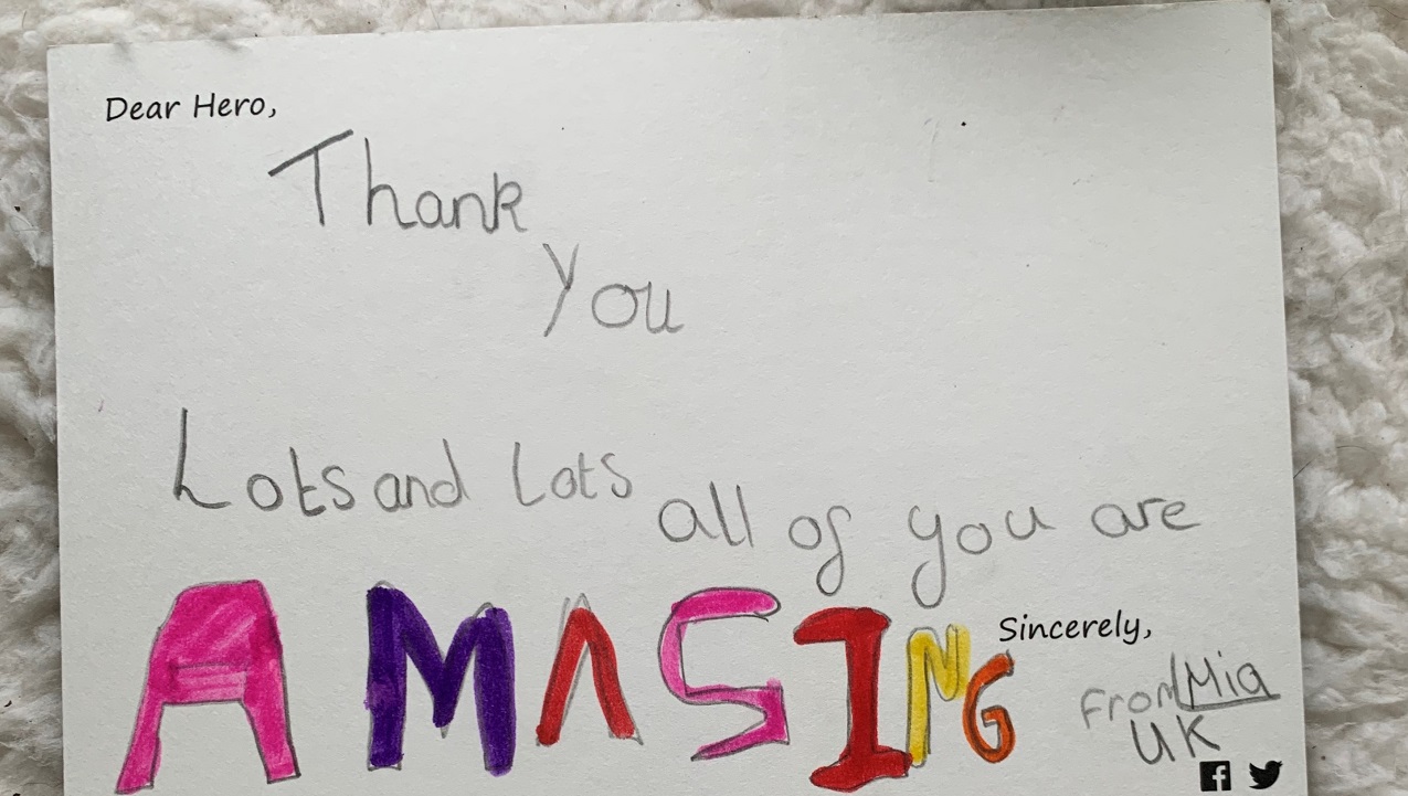 'Dear Hero' card features a handwritten message by Mia, a child from the UK. The card reads, "Thank you lots and lots. All of you are amazing."