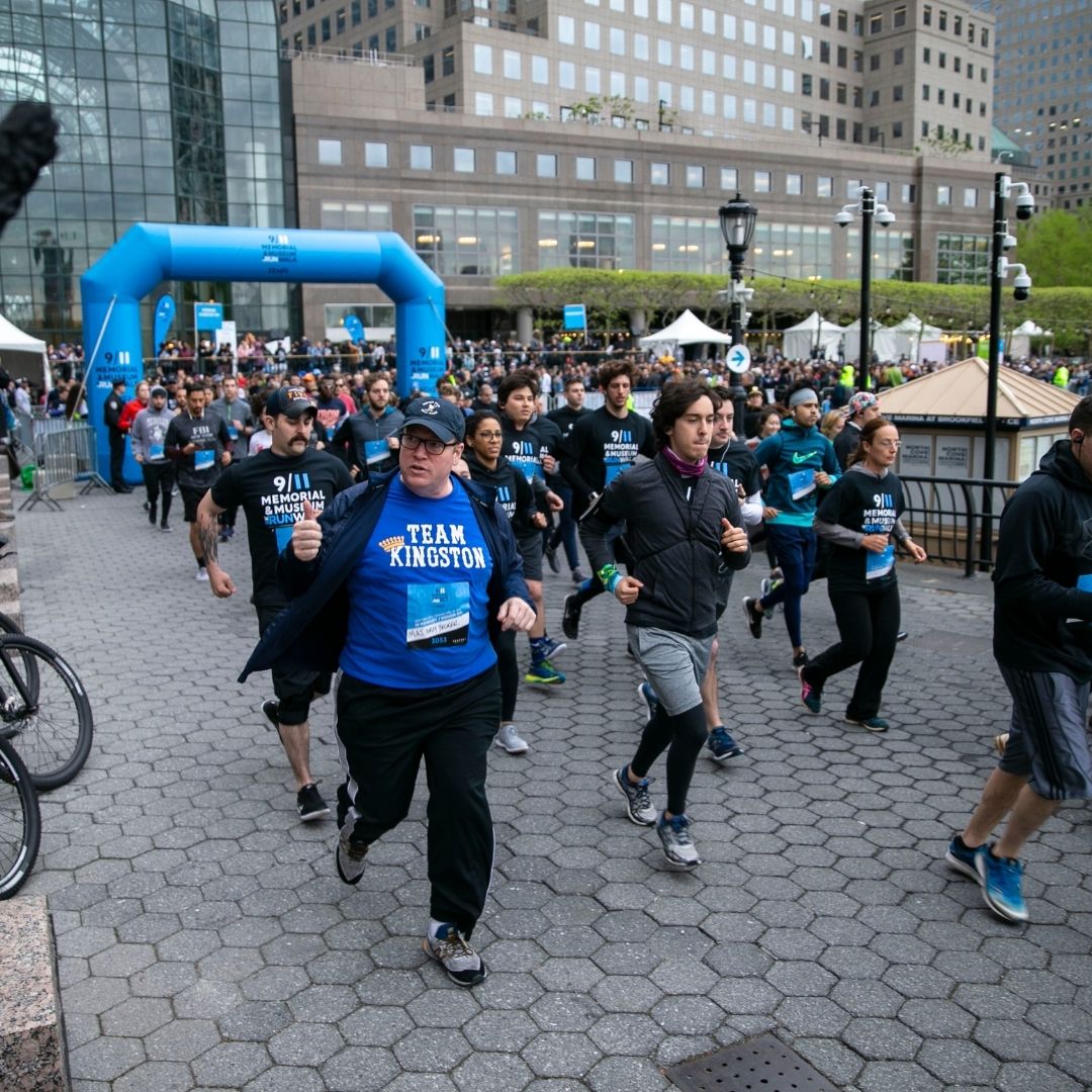 Runners along the course with city buildings in background