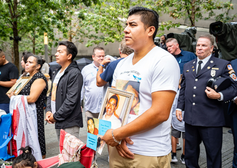 a family member carries a framed photo of a loved one killed on 9/11