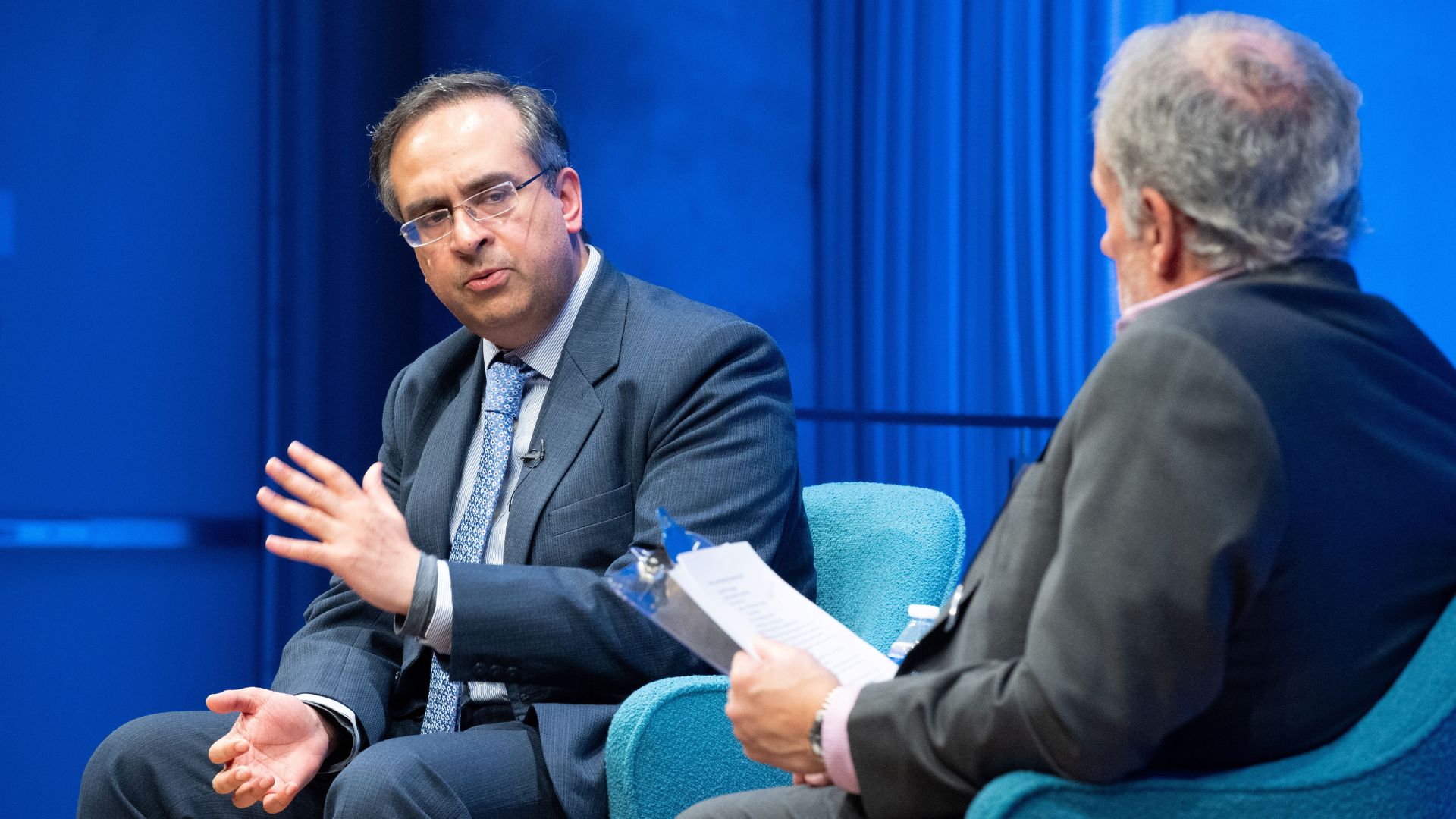 From left: Dr. Sajjan Gohel speaking to Clifford Chanin on stage.