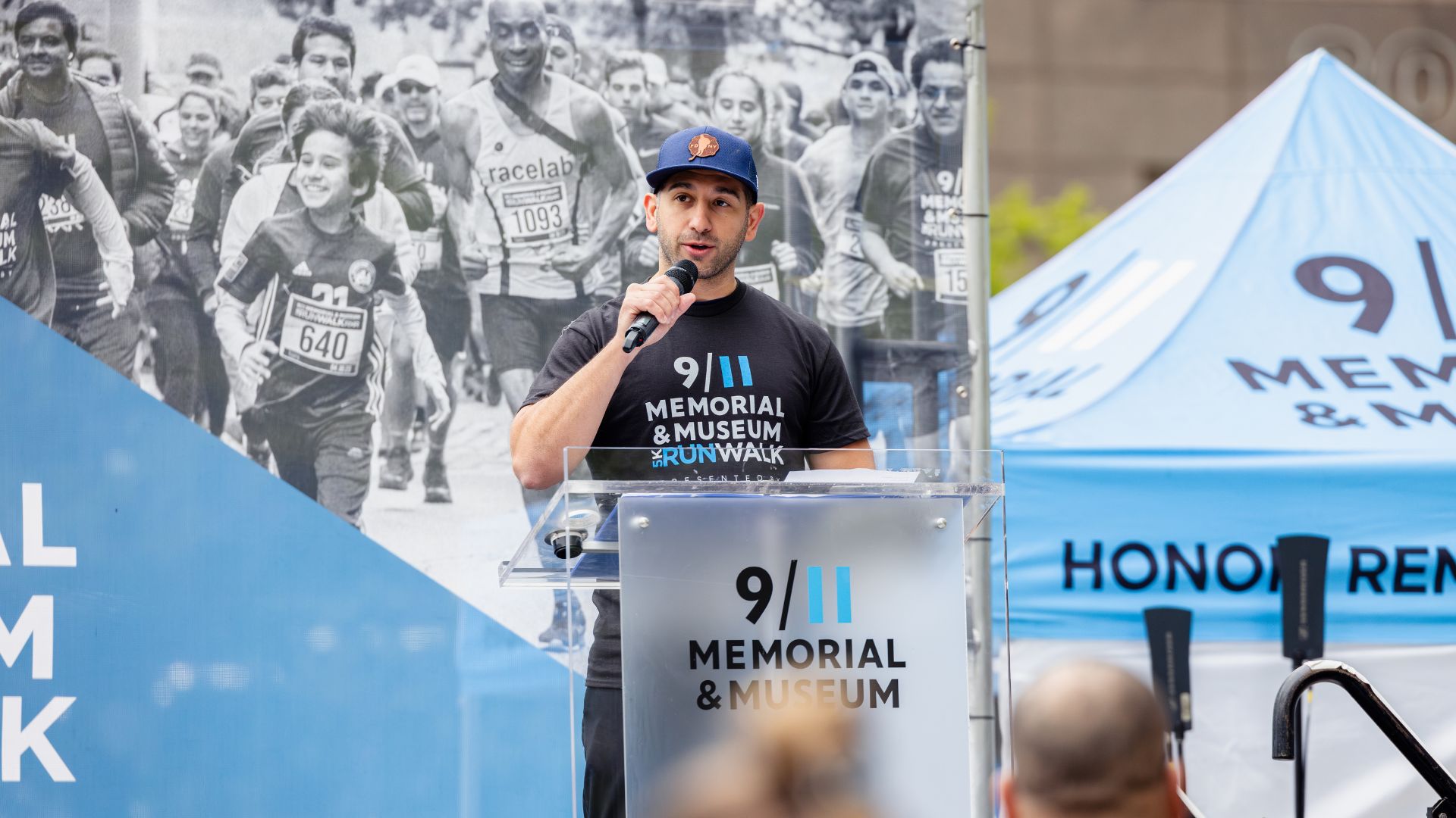 A Visionary gives a speech at a podium at the 9/11 5K run/walk