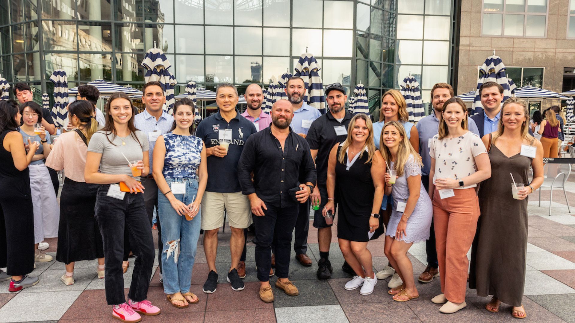 A group of Visionaries poses together at an outdoor cocktail party