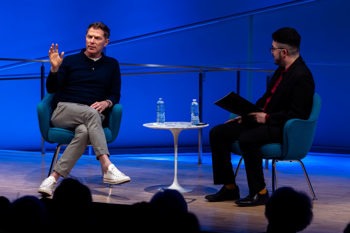 Two men speak on stage
