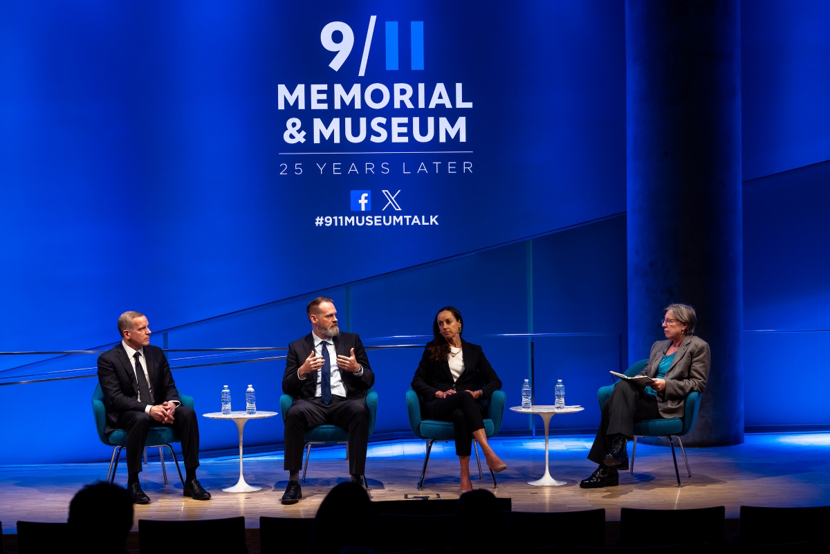 Four speakers engaged on stage.