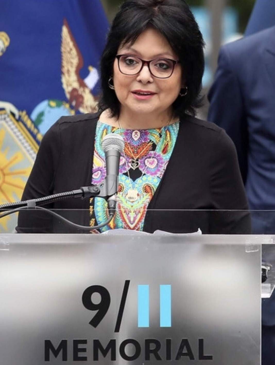 Sonia Agron speaks at a podium that reads 9/11 Memorial.