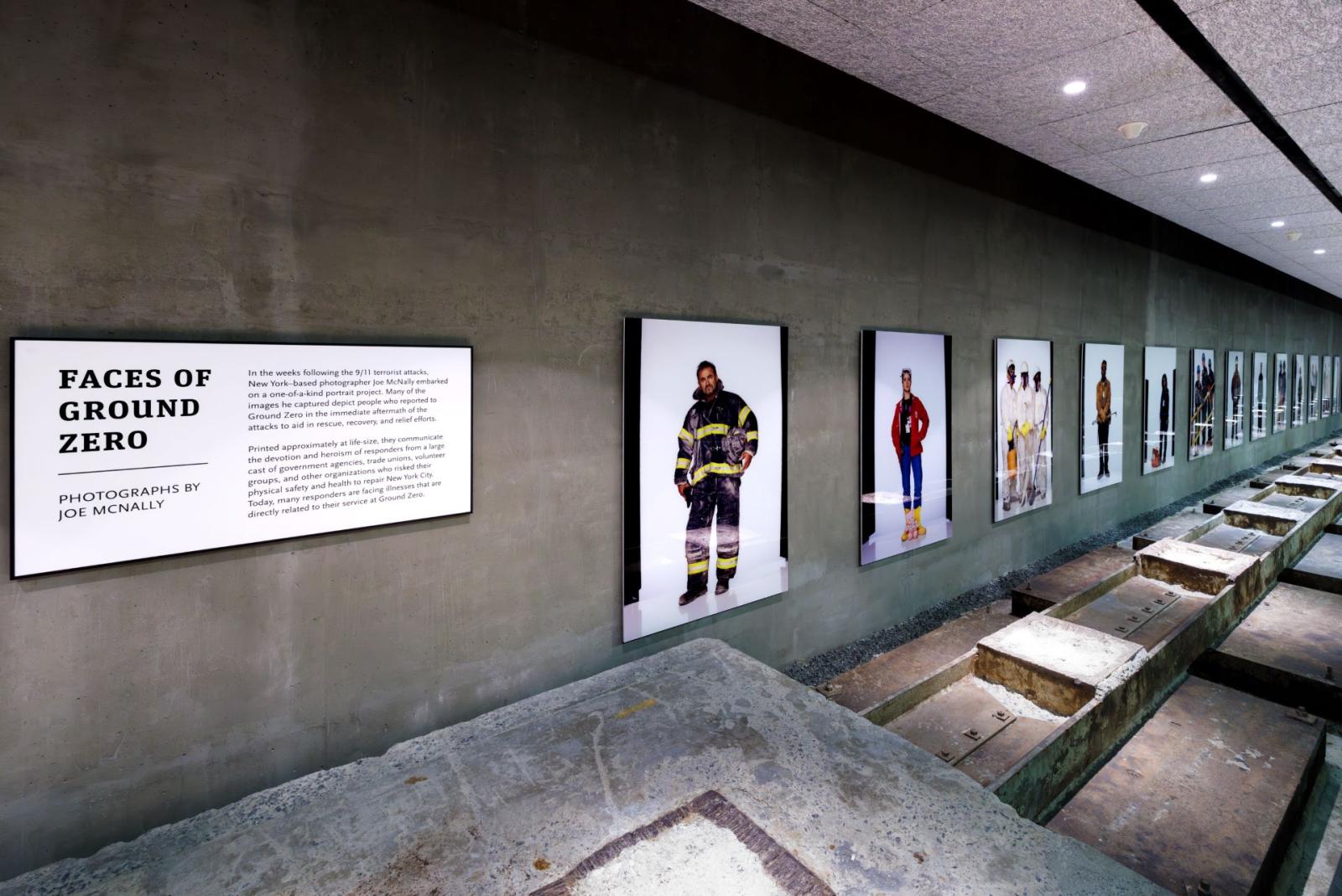 A cement hallway with large photos visible down the wall