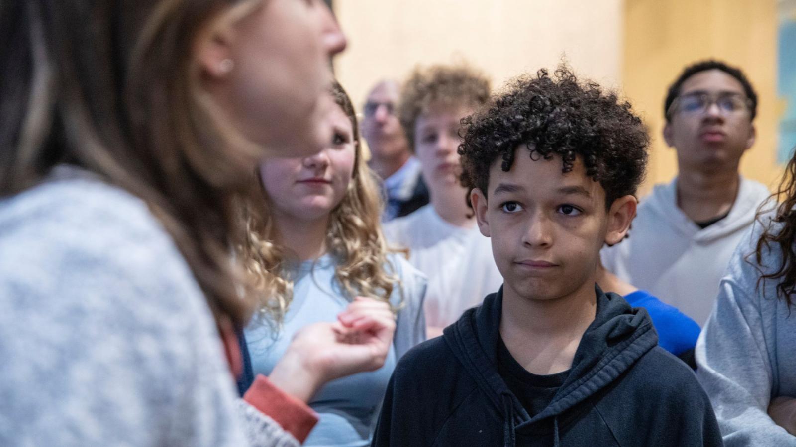 A student listens as a tour guide speaks at the Museum