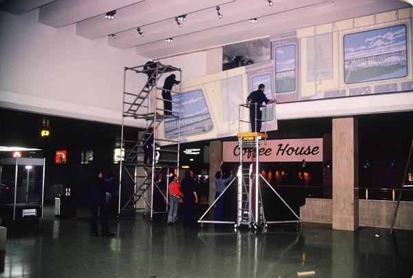 Workers stand on scaffolding at the World Trade Center PATH terminal as they install “Commuter Landscape” by artist Cynthia Mailman.