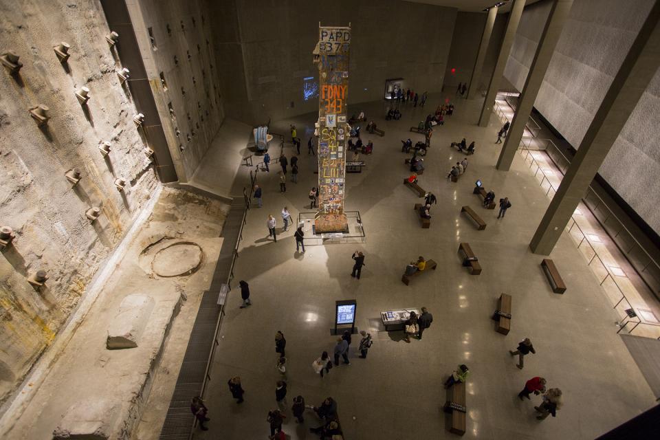 The Last Column towers above dozens of visitors in Foundation Hall at the Museum. The illuminated slurry wall is to the left.