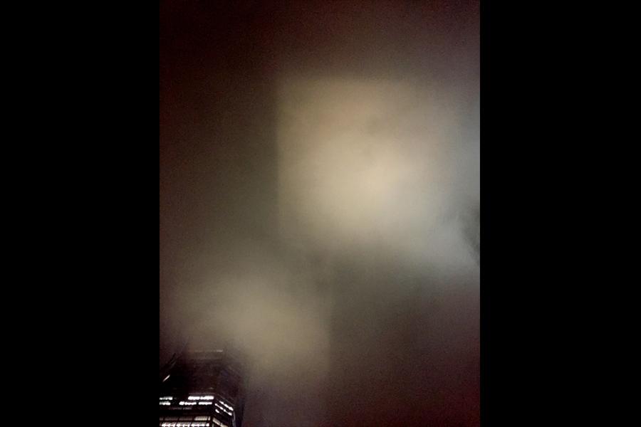 The lights of the north and south pools create two square of light in the low-lying clouds overhead in this view from Memorial plaza.