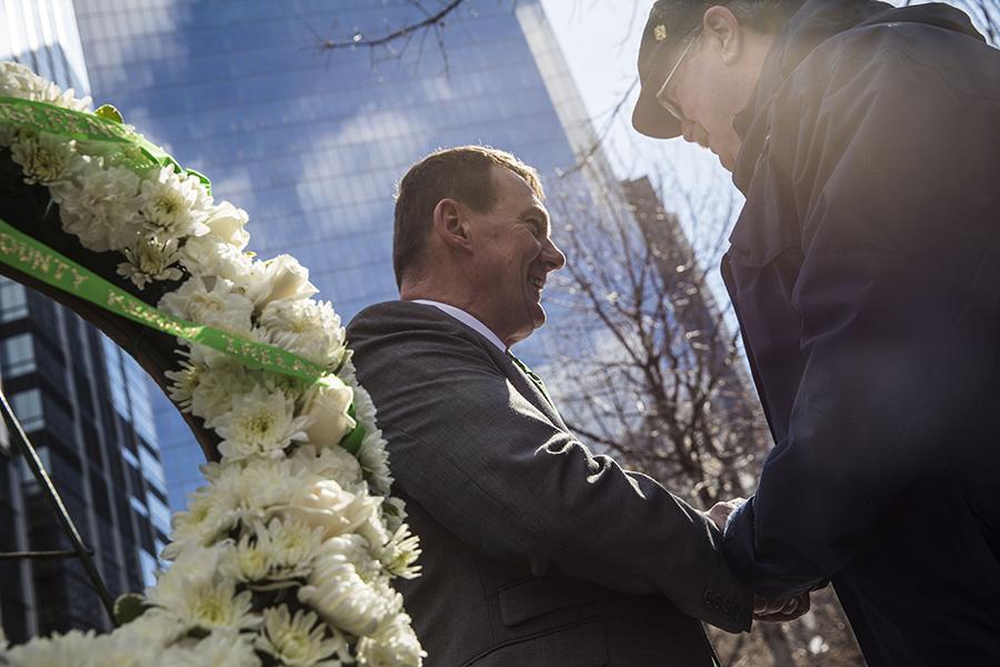 Kerry County Mayor John Sheahan shakes hands with a man after laying a wreath at the south reflecting pool.