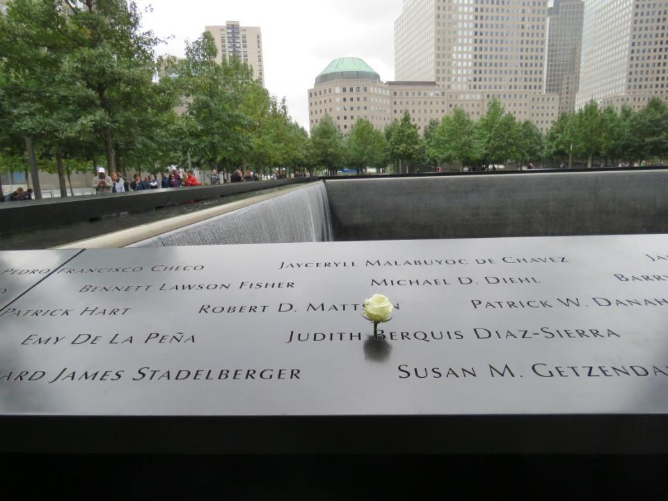 A white rose stands at the name of Judith Diaz-Sierra on the 9/11 Memorial.