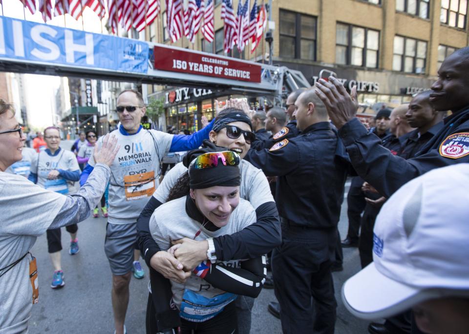 Runners embrace and give high-fives as they cross the finish line at the 9/11 Memorial 5K Run and Walk.