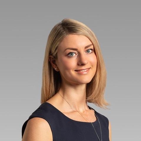 Professional headshot photo of a blonde woman wearing a sleeveless top.