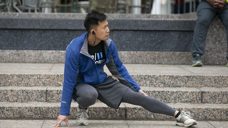 A man does lunges in front of stone steps during the 9/11 Memorial & Museum Run/Walk.